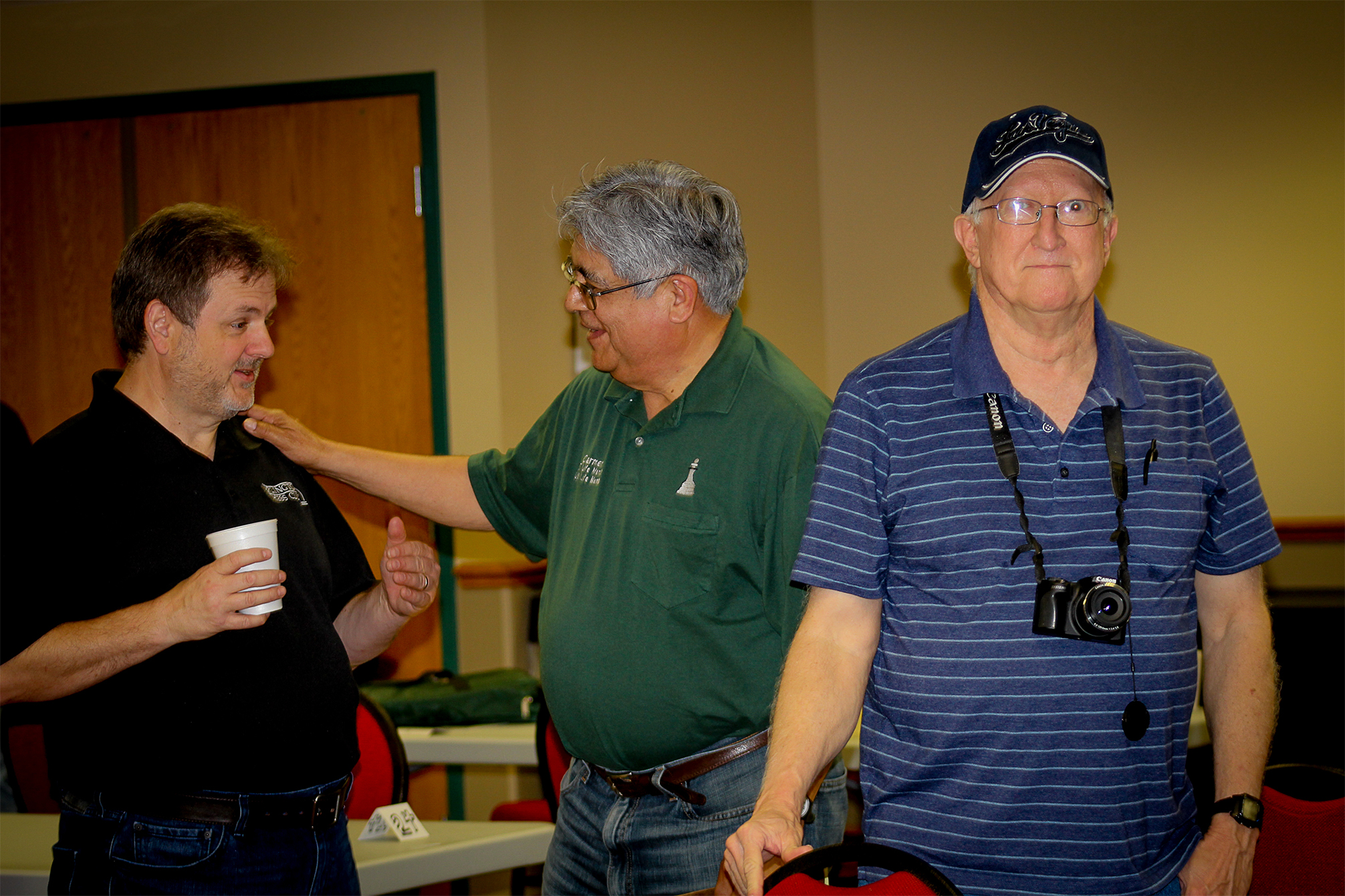 Texans Chris Wood (left) and Carmen Chairez (middle) relax and have fun telling RRSO stories.  Okie Mike Tubbs (right) seeks out another subject for his camera.  Photo by Sheryl McBroom.